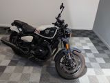 une moto noire et blanche garée sur un sol à damier