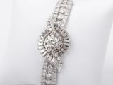 a close up of a diamond and white gold bracelet on a pillow