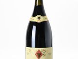 la bouteille de vin rouge est posée sur une surface blanche