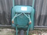 a green wheelbarrow with a sign on the side of it
