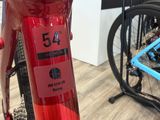 a close up of a red bike with a blue bike rack