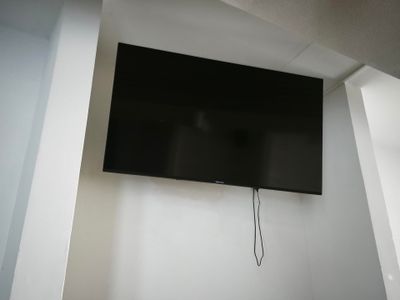 une télévision à écran plat fixée au mur dans un coin de la pièce