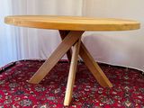 a wooden table with three wooden legs on a red carpet