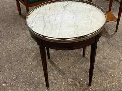 a table with a marble top and two chairs in the background