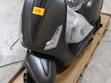 un scooter qui se trouve dans un carton posé par terre