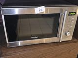 a microwave sitting on top of a wooden cabinet