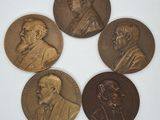 quatre médailles de bronze représentant des hommes en costume-cravate sur un fond blanc