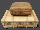 two pieces of luggage sitting on top of each other