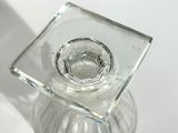 a clear glass candle holder on a white table