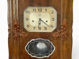 une horloge en bois exposée sur un fond blanc