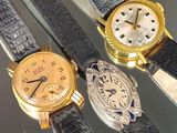 Trois types de montres différents sont exposés sur une table en verre