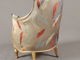 an upholstered chair with a feather pattern on the back of it