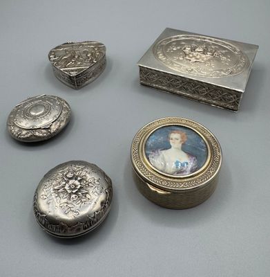 Plusieurs objets en argent sont posés les uns à côté des autres sur une table.