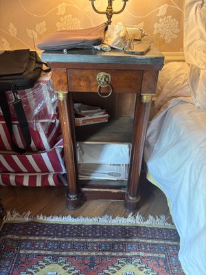 une petite table sur laquelle est posée une valise, à côté d'un lit