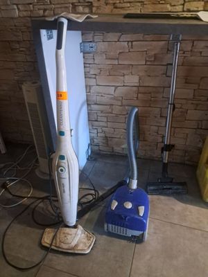 un aspirateur et une serpillière posés sur le sol d'une pièce