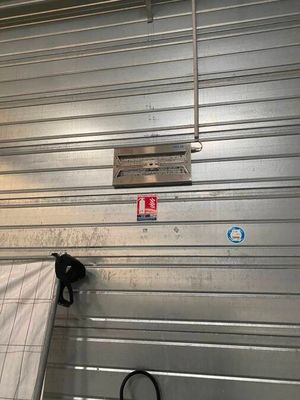 une photo d'une porte de garage métallique avec un matelas posé à même le sol