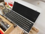 a laptop computer sitting on top of a workbench in a garage