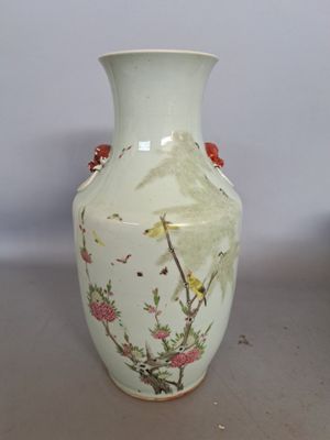 un vase blanc avec des fleurs et des oiseaux peints dessus