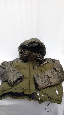 une image représentant une veste et un sac de couchage posés sur une surface blanche