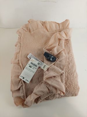 une couverture rose sur laquelle est posé un téléphone portable