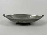 an old silver bowl with handles on a stand on a white surface