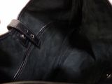 someone is holding a black purse with a black strap