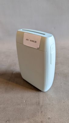 un grille-pain blanc posé sur une table, sur lequel est collée une étiquette