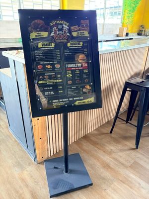 un panneau présentant le menu, posé sur un support, dans un restaurant