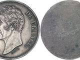 a close up of a coin on a white surface with a white background