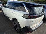 the rear end of a white car parked in a parking lot