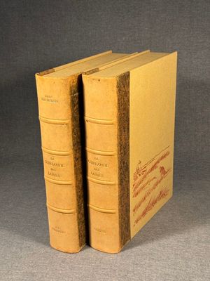 two old books are sitting on a table with a gray background