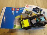 a box of lego city vehicles on the floor