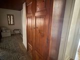 a wooden door in the hallway leading to a bed