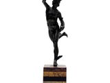 statue d'un homme tenant une raquette de tennis, posée sur un socle en marbre