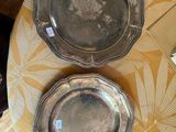 deux assiettes en argent posées sur une table recouverte d'une nappe jaune