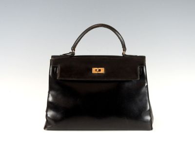 un sac à main en cuir noir muni d'un fermoir doré sur la poignée