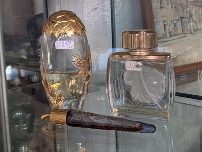 a glass table with a bottle of perfume and a cigar on it