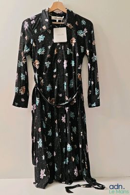 robe noire à imprimé floral, à manches longues et avec une ceinture, suspendue à un cintre