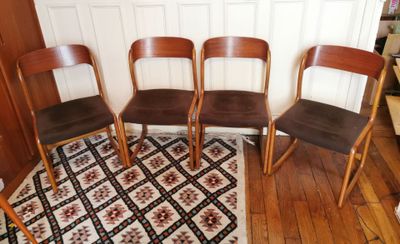 quatre chaises en bois alignées sur un tapis