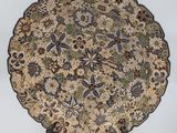 a decorative plate with a floral design on a stand