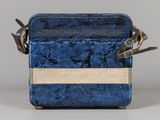 a blue suitcase with a handle and some scissors in it