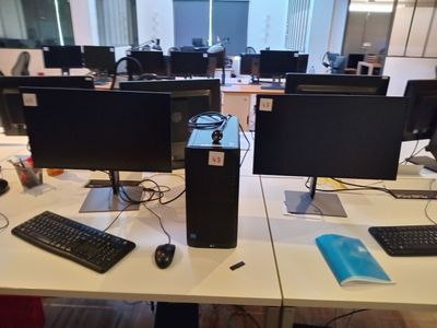 deux écrans d'ordinateur et un clavier posés sur le bureau