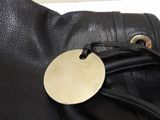 a black purse with a gold tag on it