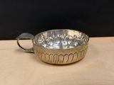 an image of a metal bowl with a handle on a wooden table
