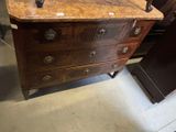 a wooden dresser with a marble top in a room