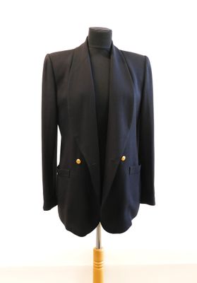 a black jacket on a mannequin stand with a white background