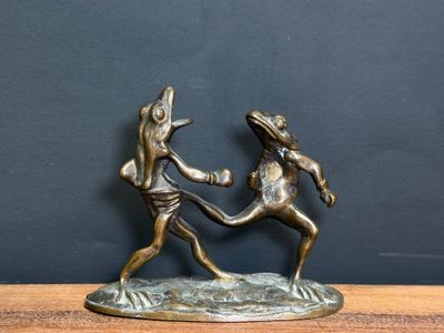 bronze figurine of two people fighting with each other on a table