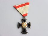 une médaille ornée d'une croix sur un fond blanc