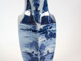 a blue and white vase sitting on a white surface