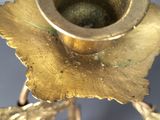 a gold candle holder with a flower design on it